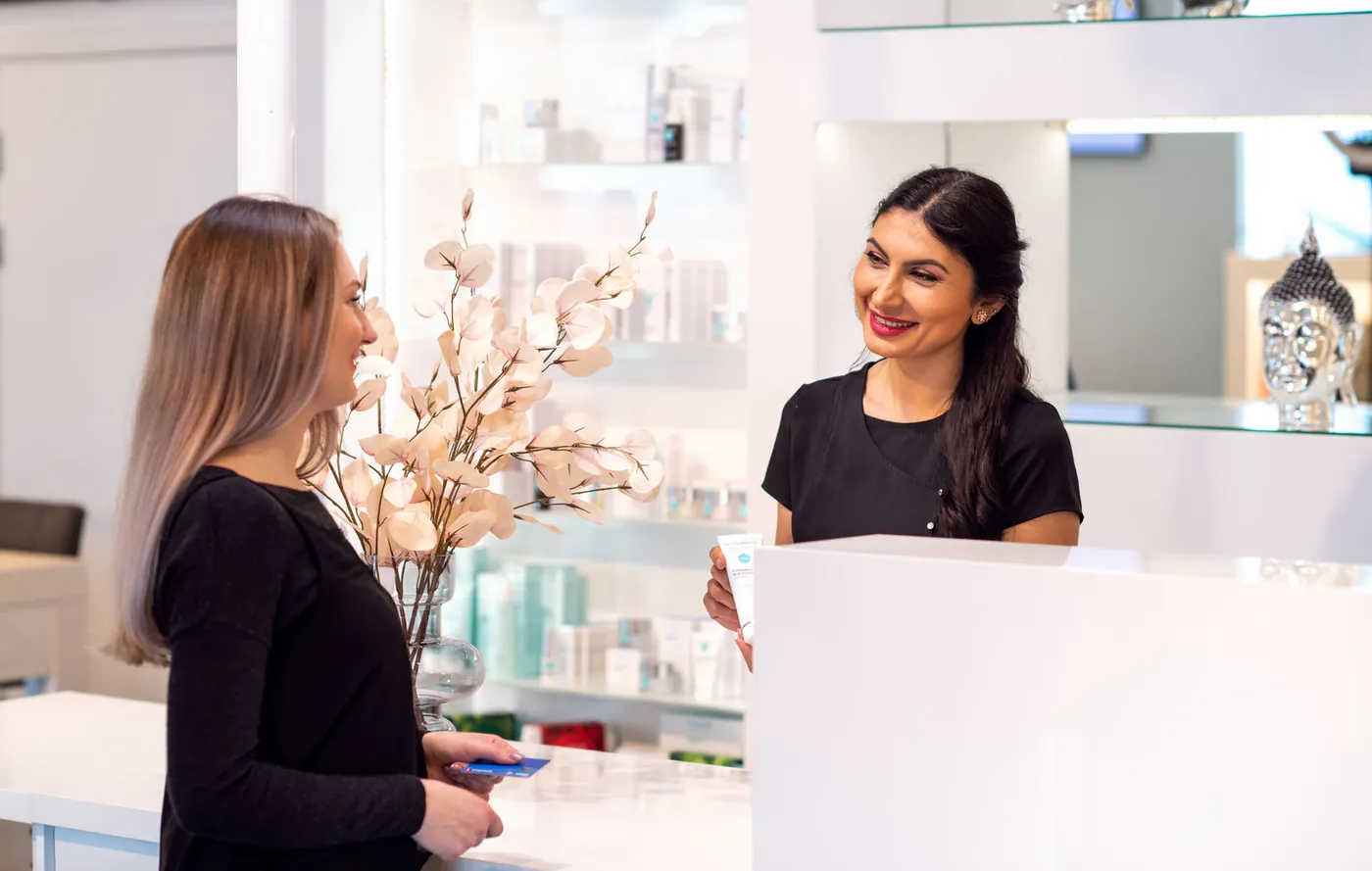 Kosmetolog tar imot en kunde i resepsjonen hos Fab.Lounge Medispa